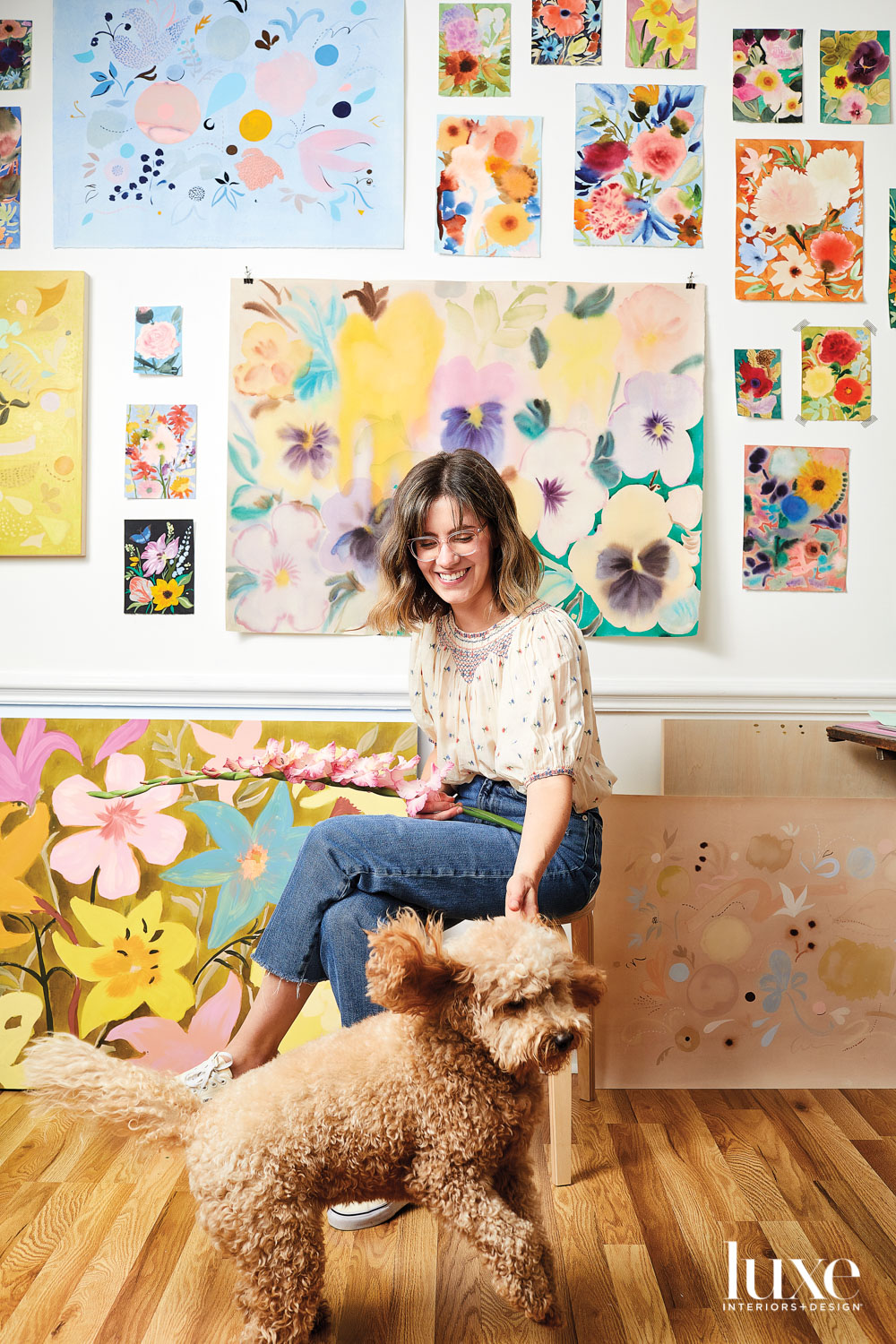 Woman sitting in front of artwork with dog