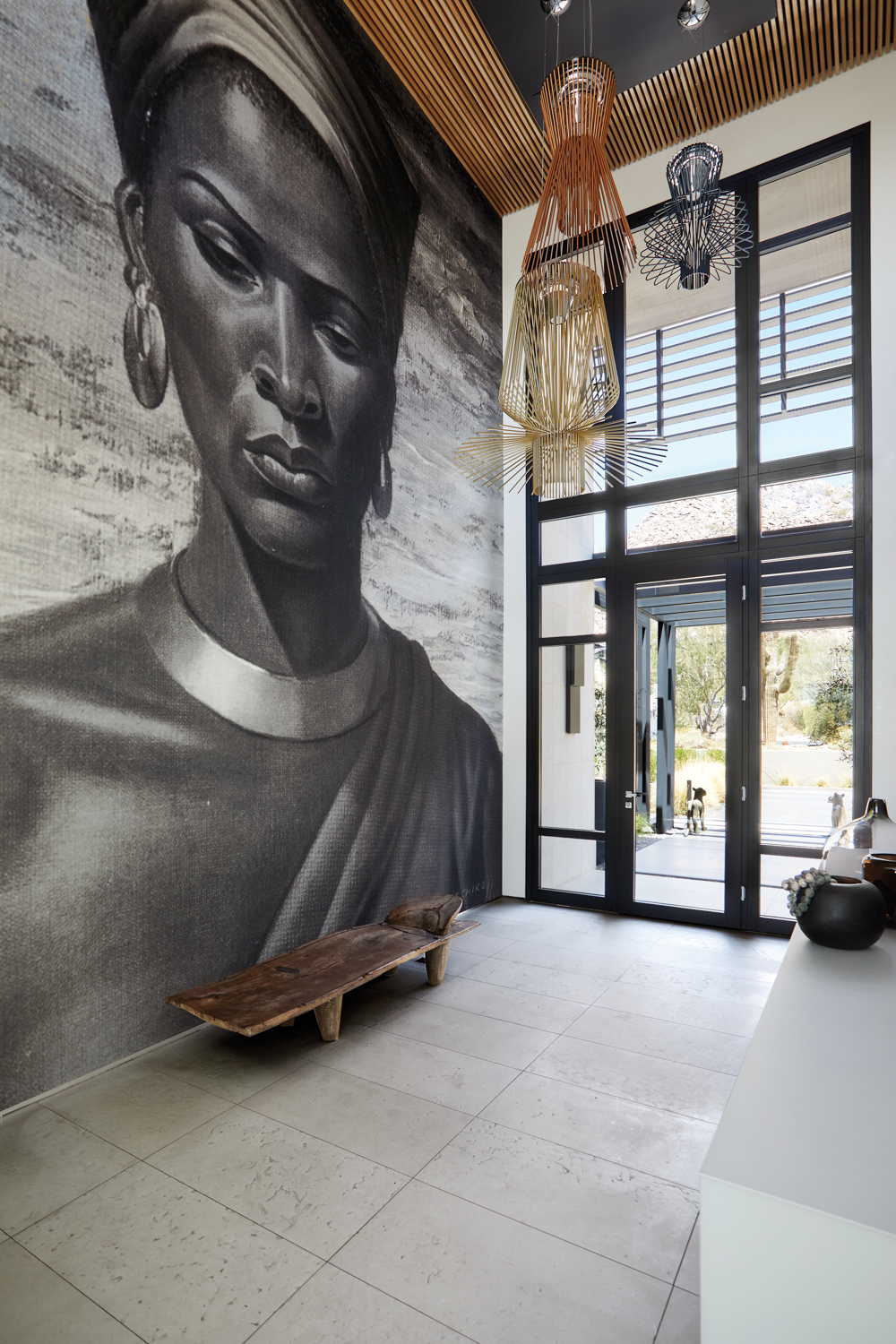 A double-story entryway with a floor-to-ceiling black-and-white mural of an African woman.