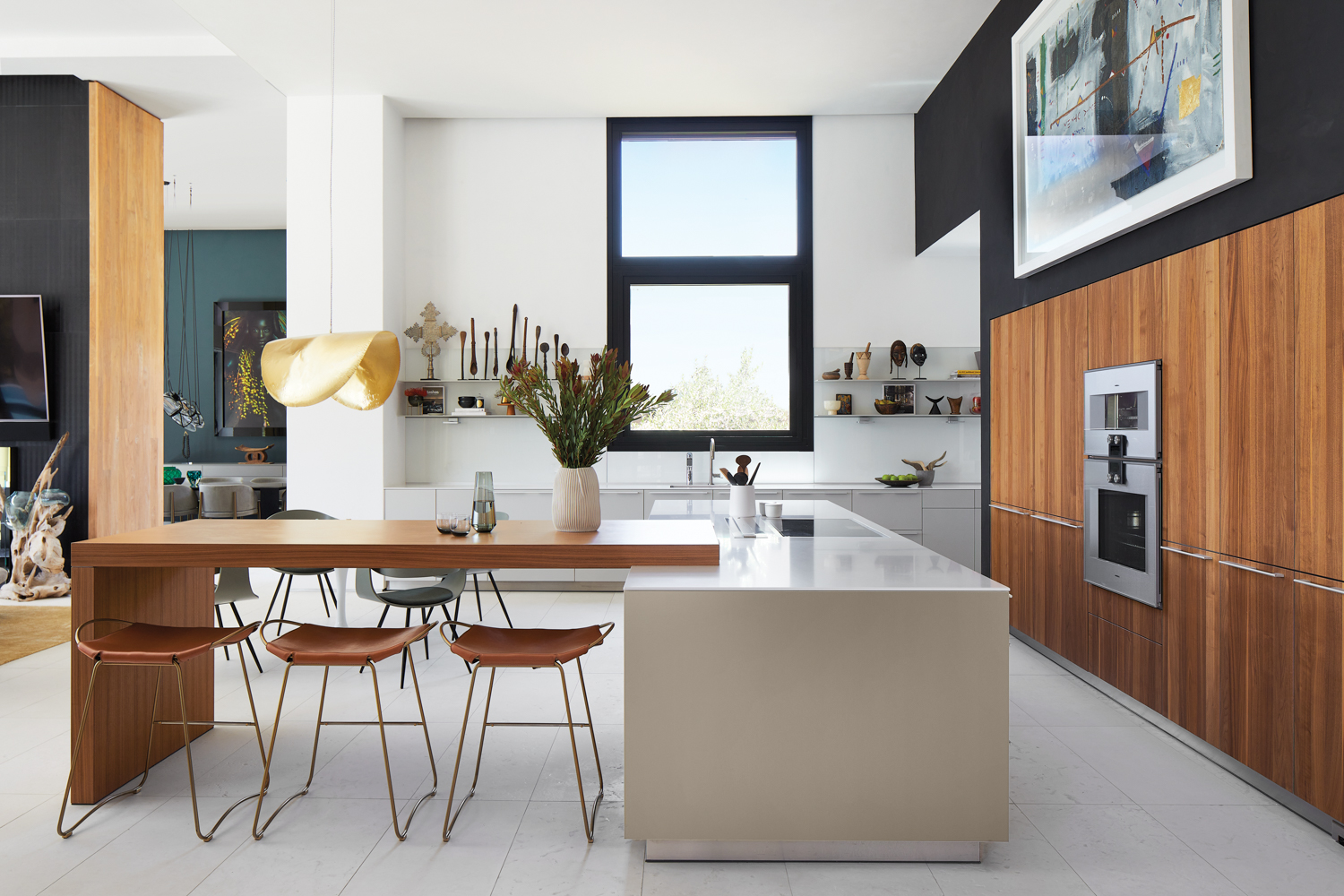 A kitchen with a walnut countertop overlapping a white island. The appliances are built into the walnut cabinetry.