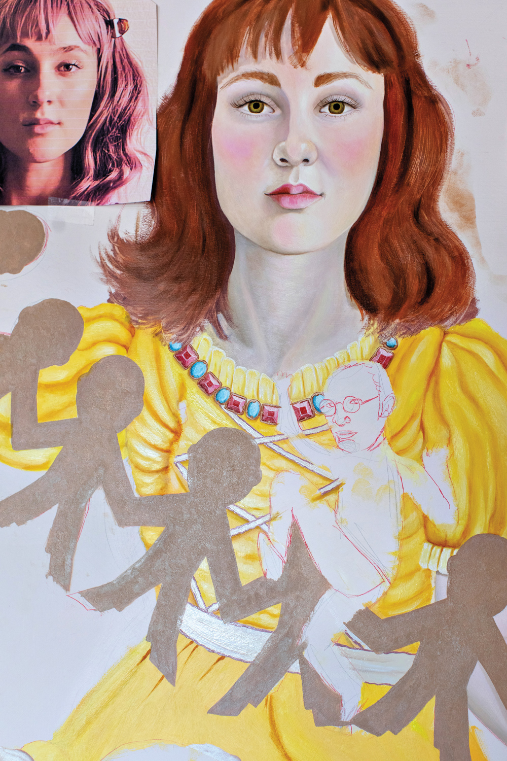 A painting of a girl in a yellow dress holding paper cut outs. A smaller picture of the girl hangs next to the painting.