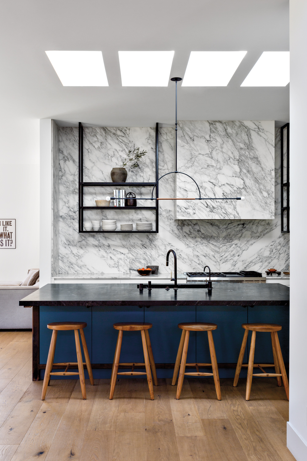 minimalist kitchen with marble on countertop and backsplash; also the island has counter seating