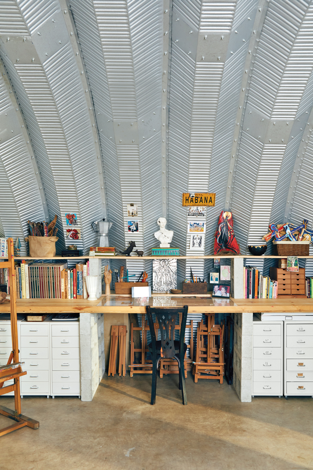 art studio with corrugated metal walls and desk with art supplies