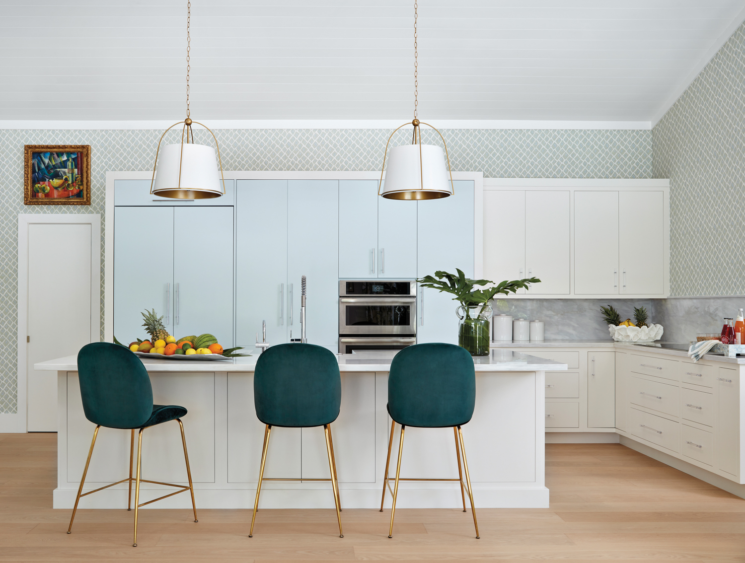 kitchen with blue cabinetry, white island pendants and dark green velvet counter stools