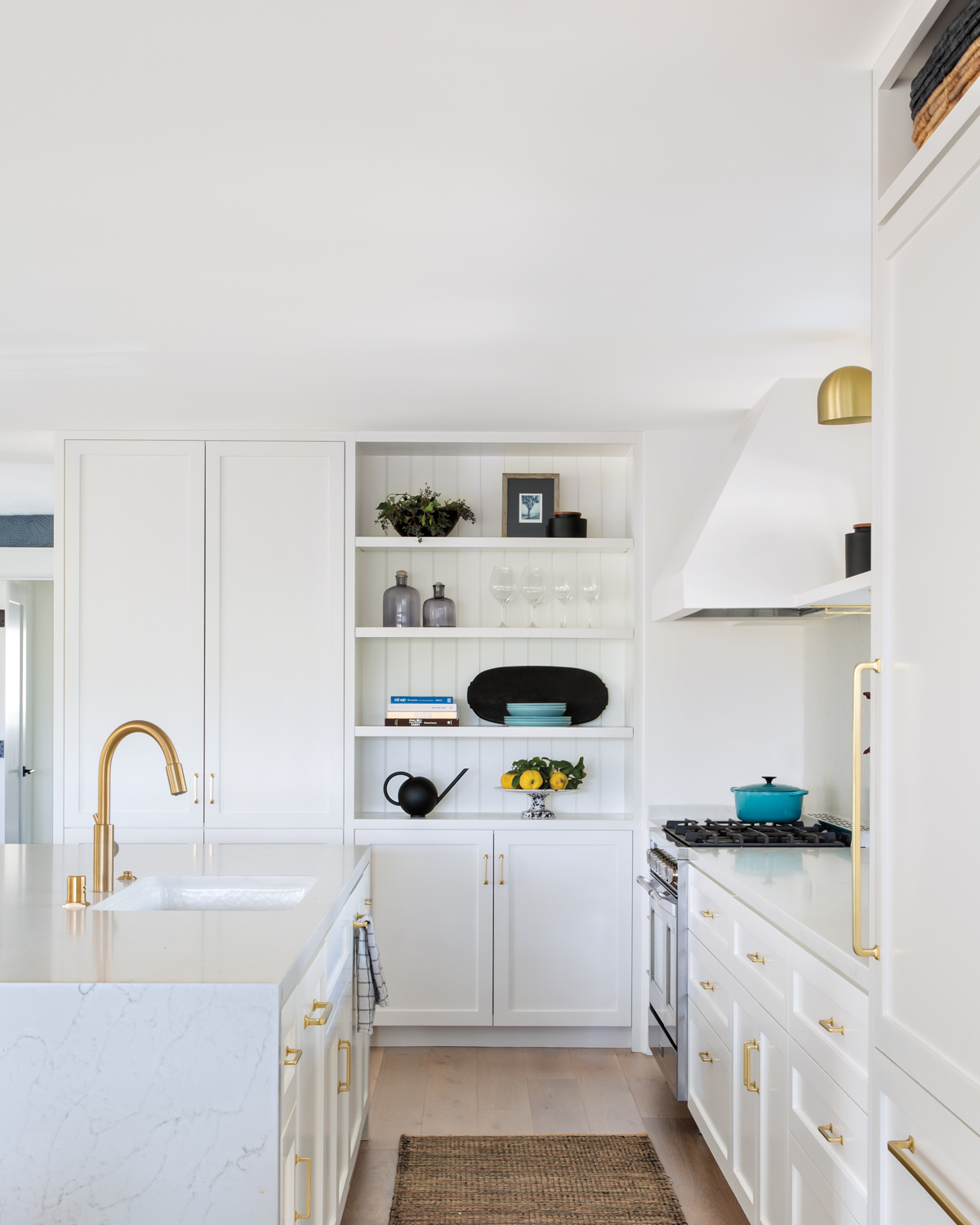 white kitchen cabinetry with brass...