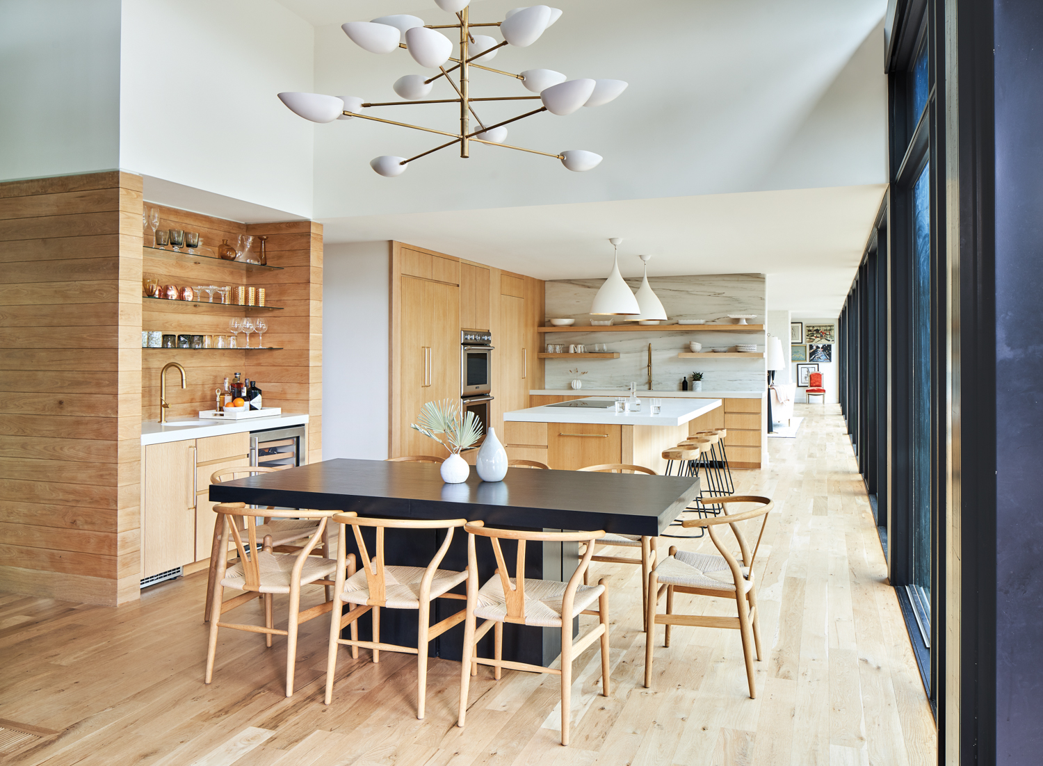 Open-format kitchen with modern dining area and pale wood cabinetry