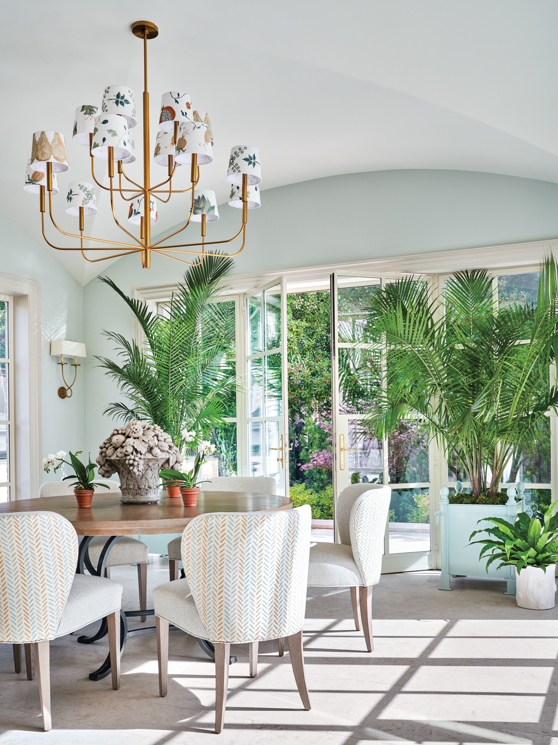 sun room with a dining table and chairs and views of lush landscaping