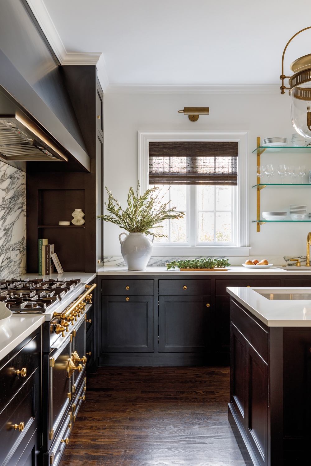 A kitchen with black cabinetry,...