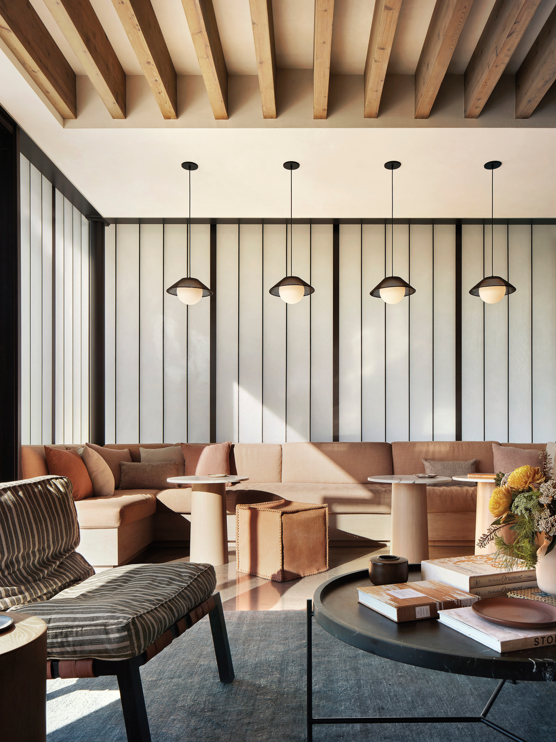 Tasting room with slatted-wood ceiling and banquette seating upholstered in a light-colored fabric.
