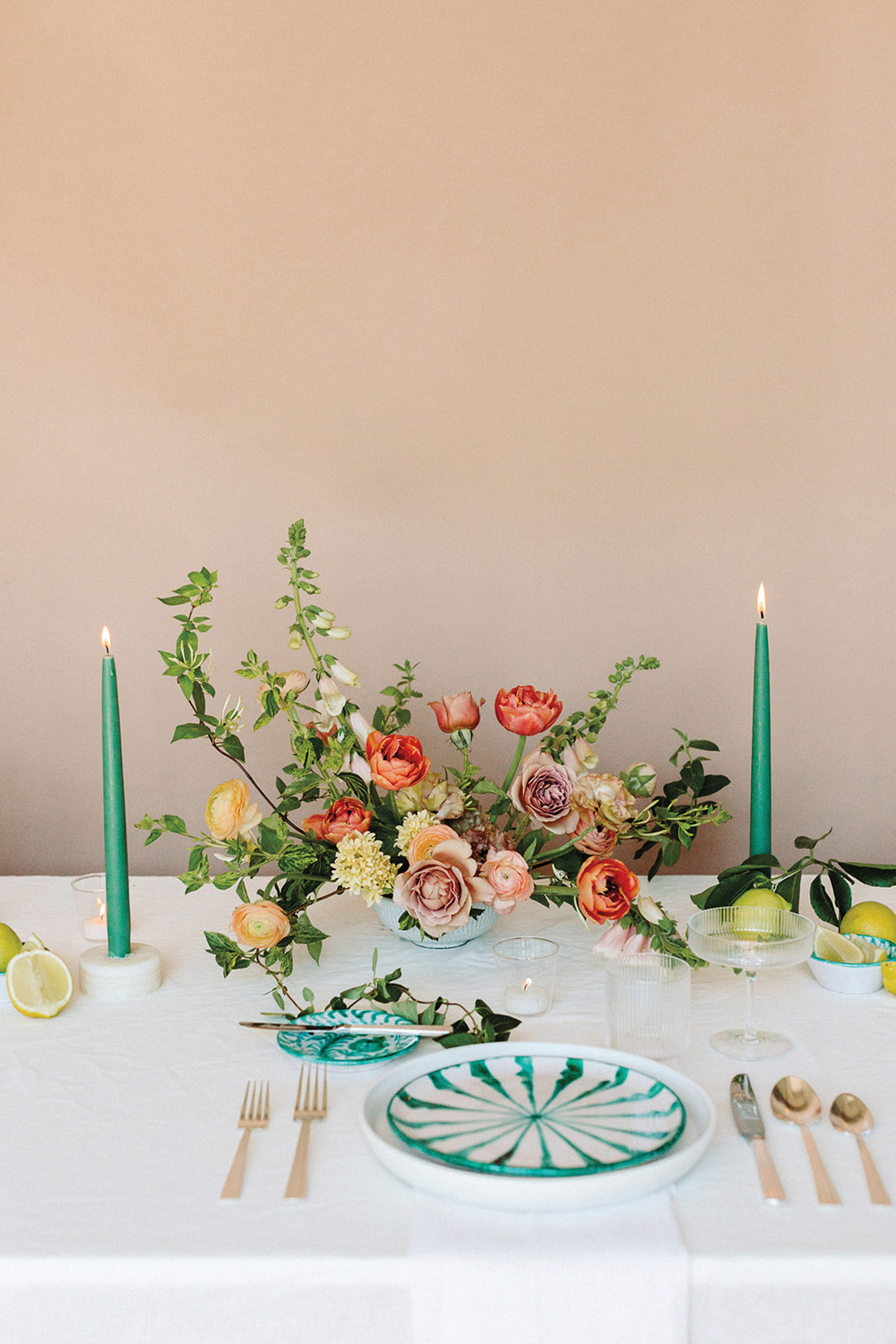 Tablescape with green candles and red, pink and yellow florals.