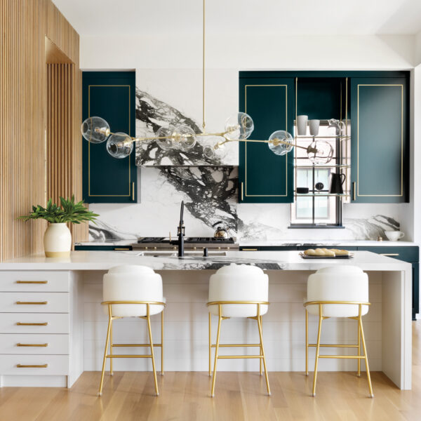 L.A. Style Sets The Stage For A Chicago Couple’s Dream Home white kitchen island topped with a black-and-white porcelain countertop paired with forest-green cabinetry