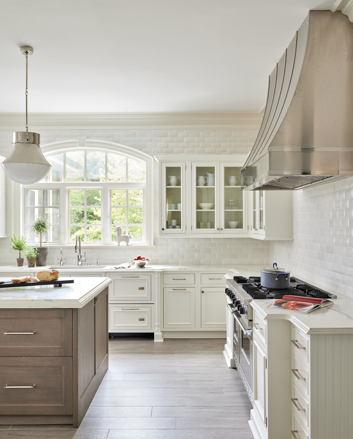 A white kitchen with pillowed...