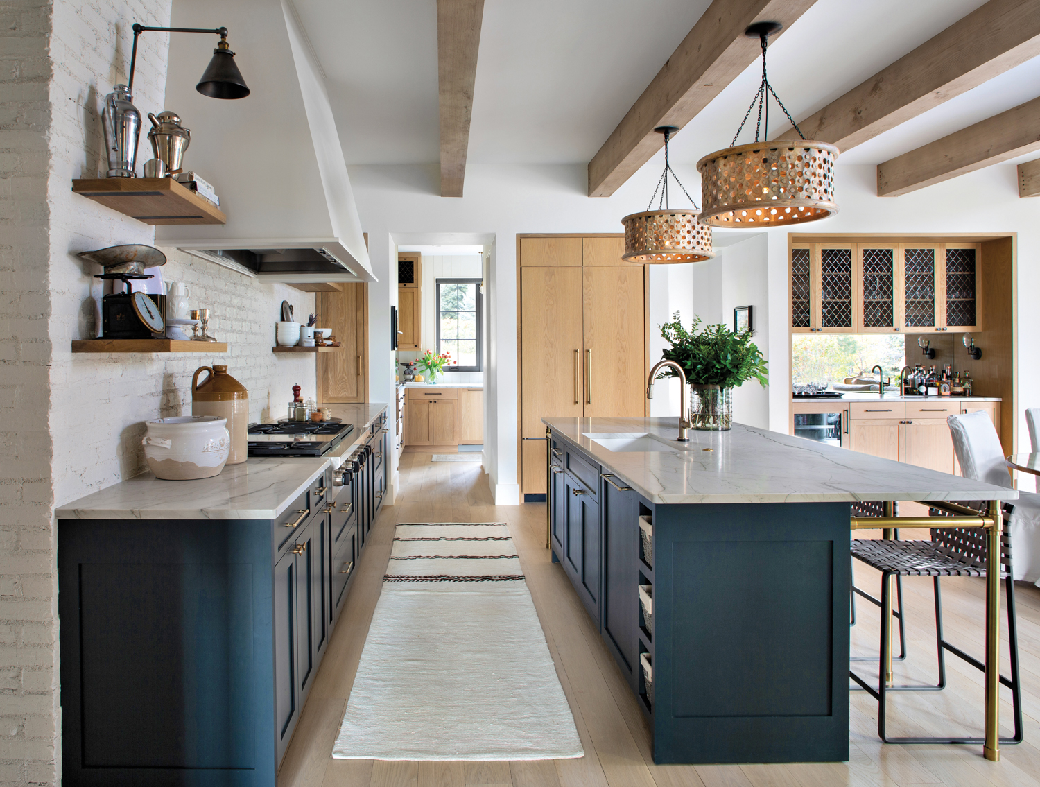 kitchen with rustic wood beams and a white-painted brick wall, with blue-black custom cabinets