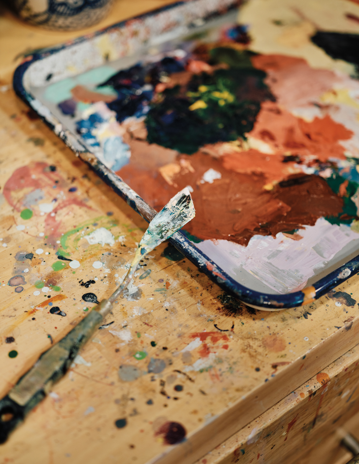 a paint covered palette knife and paint pan