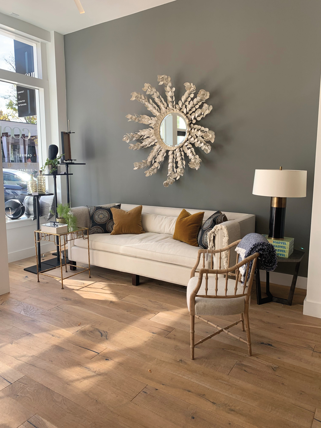 beige mirror and sofa against grey wall displayed in furnishings showroom