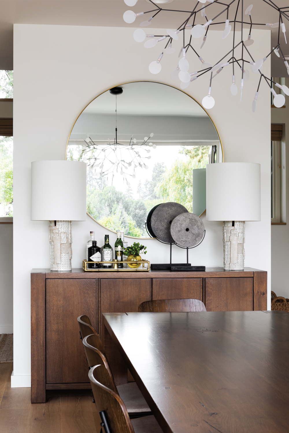 modern dining room console holds oversized round mirror