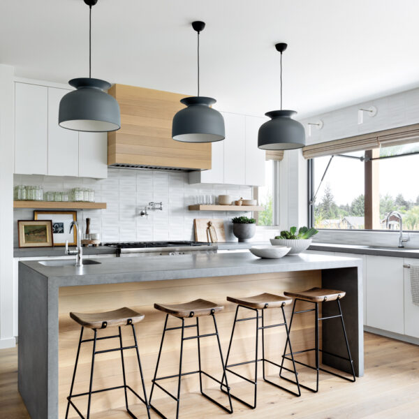See How Classic Cottages Inspired This Modern Oregon Home airy modern kitchen features pendant lights over island counter