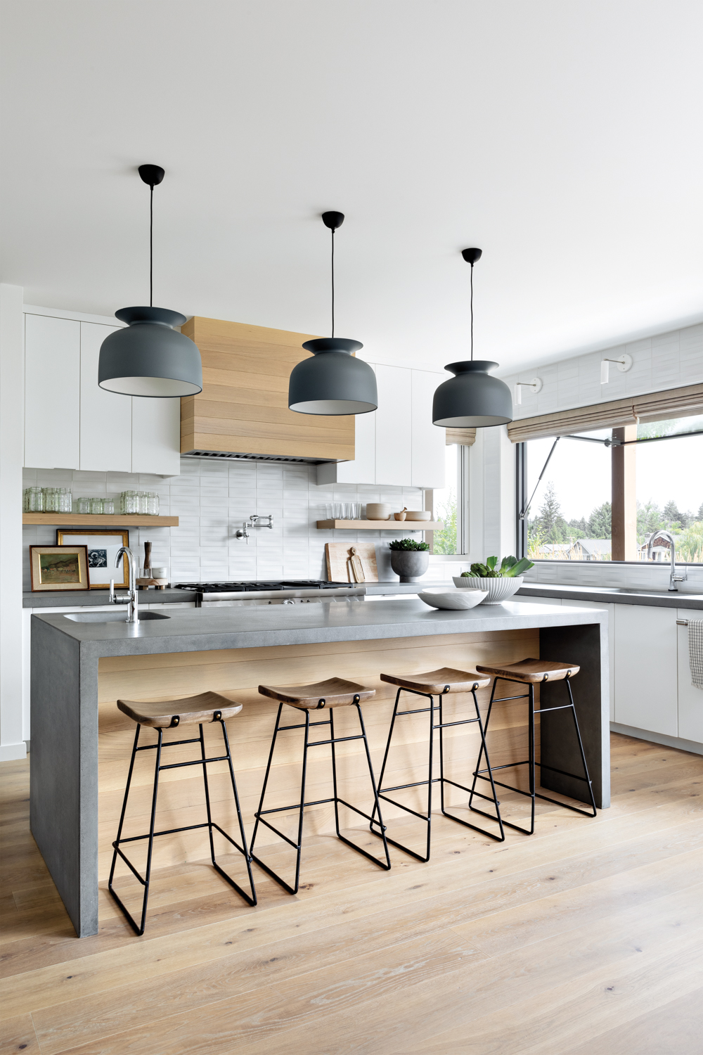 airy modern kitchen features pendant lights over island counter