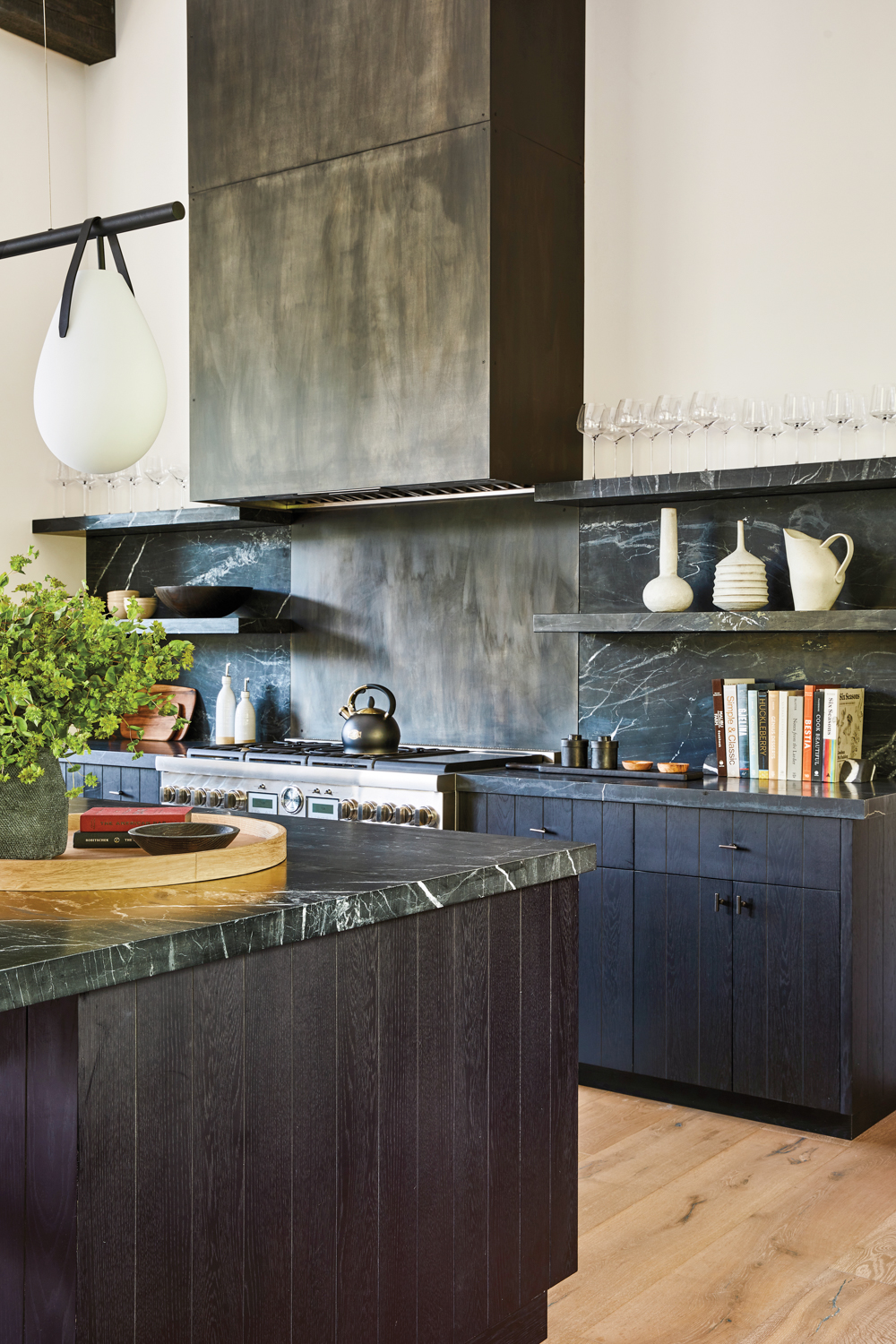 kitchen range is topped with a dark, patinated range hood