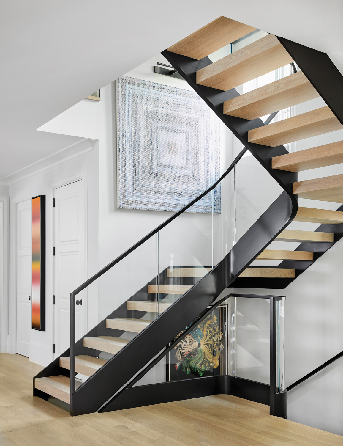 Main stairwell with black and glass rails and open treads