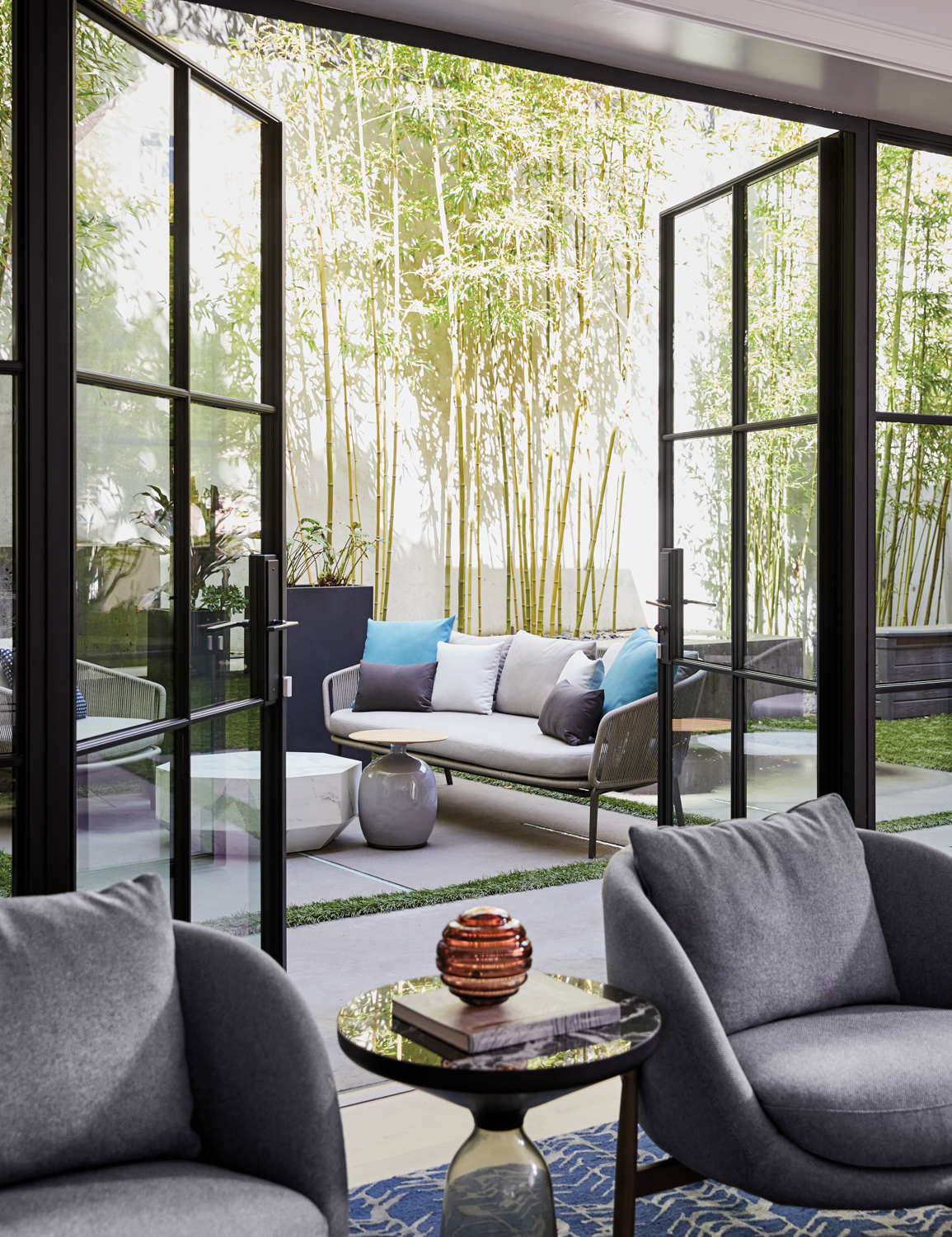 steel-and-glass doors open from gray family room to terrace