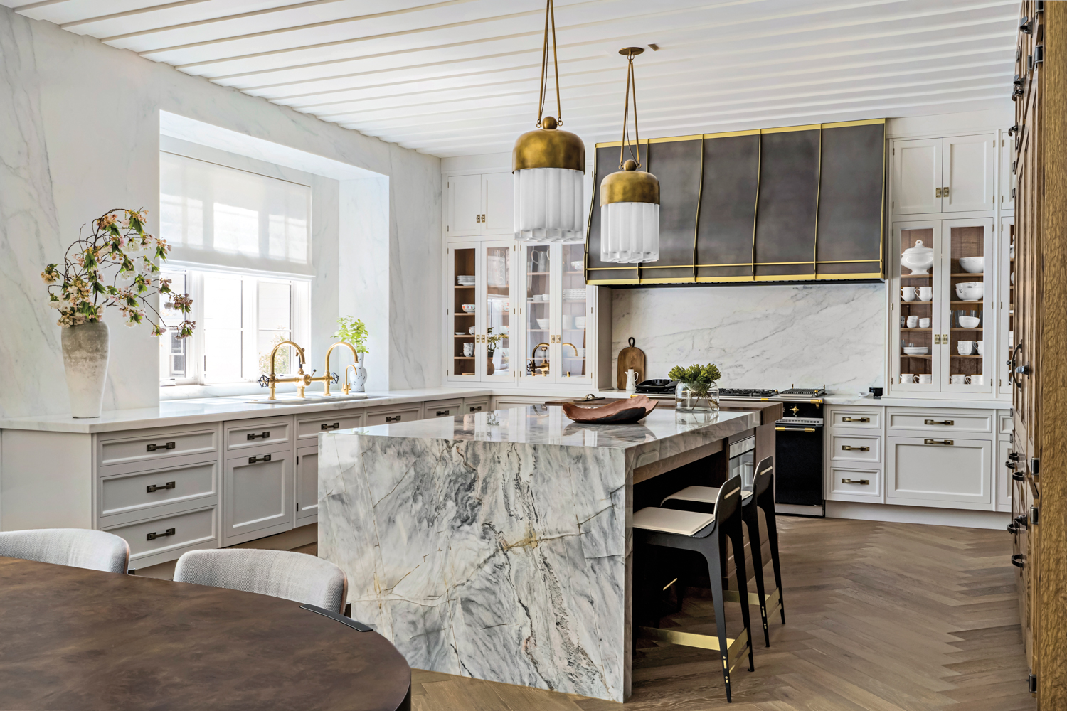 A quartzite countertop with strong veining covers the top and sides of the kitchen island.