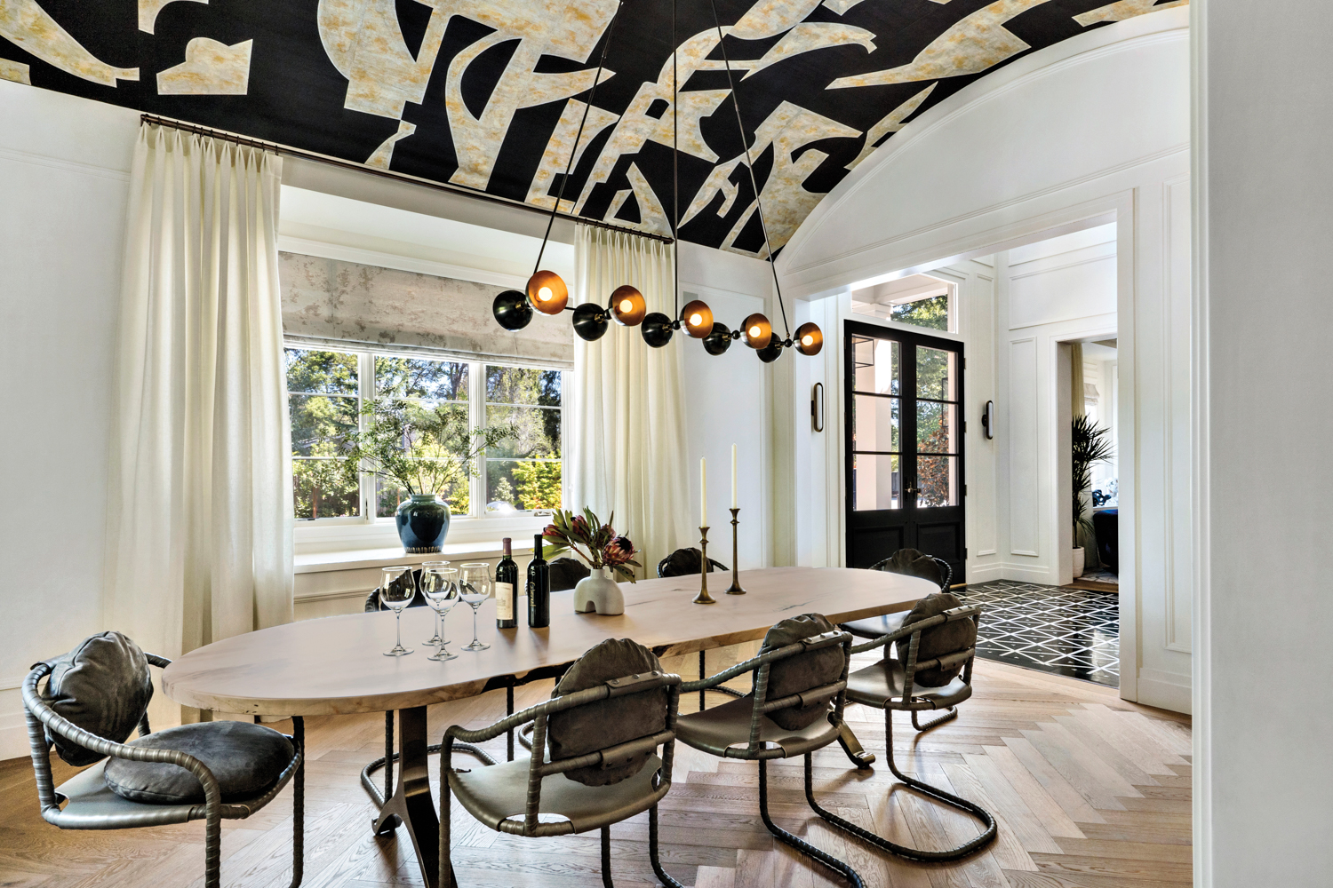A geometric, black-and-white wallpaper covered the barrel ceiling in the dining room.