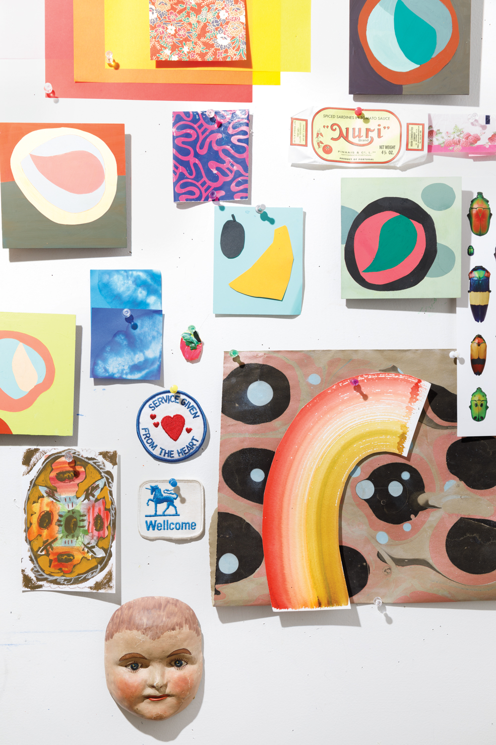 Collage wall of various abstract artworks and colorful small paintings