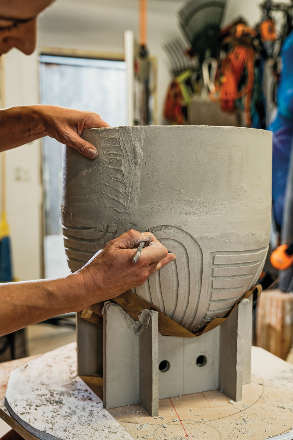 ceramicist carving designs into one of her clay objects