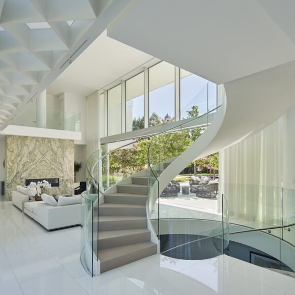 modern stair case with glass railings, marble floors and floor to ceiling windows in Northern California home by De Mattei Construction