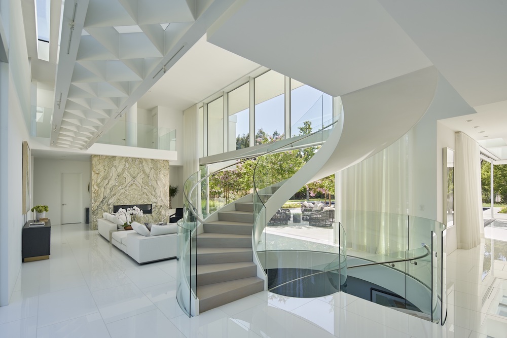 modern stair case with glass railings, marble floors and floor to ceiling windows in Northern California home by De Mattei Construction