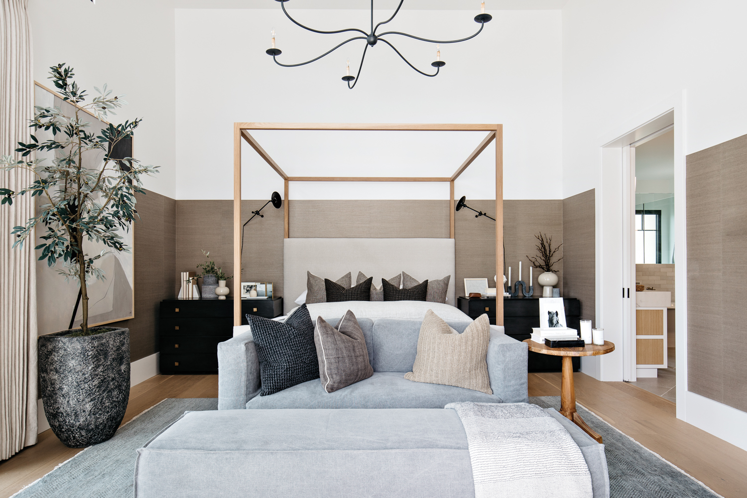 A gray-and-white main bedroom with...