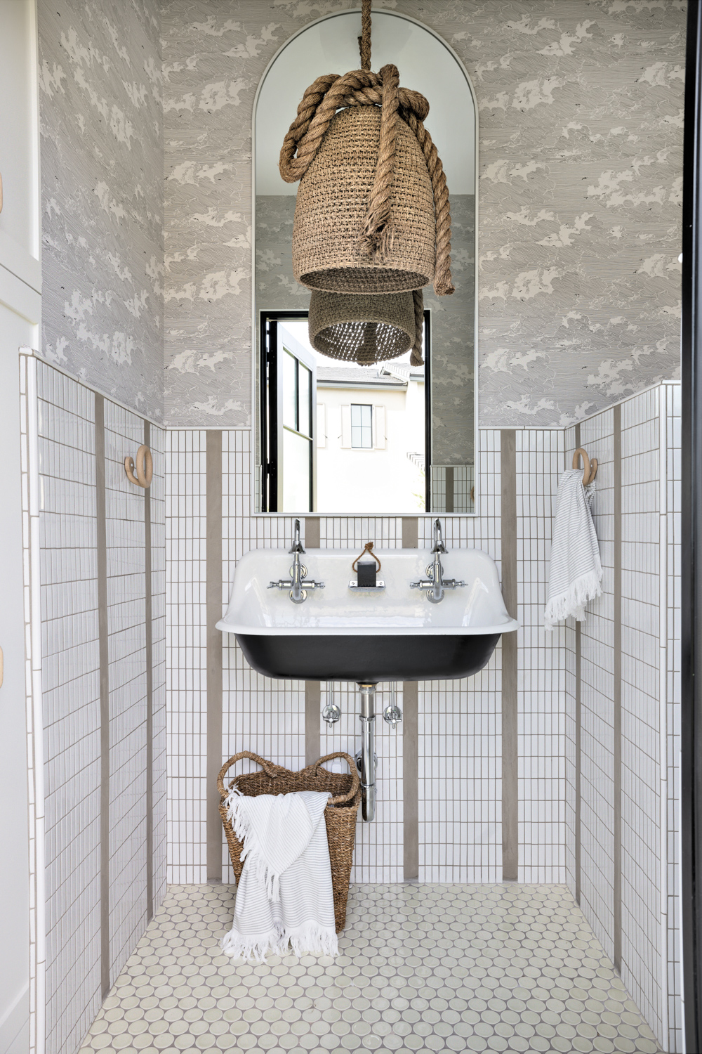 A gray-and-white bathroom with large...