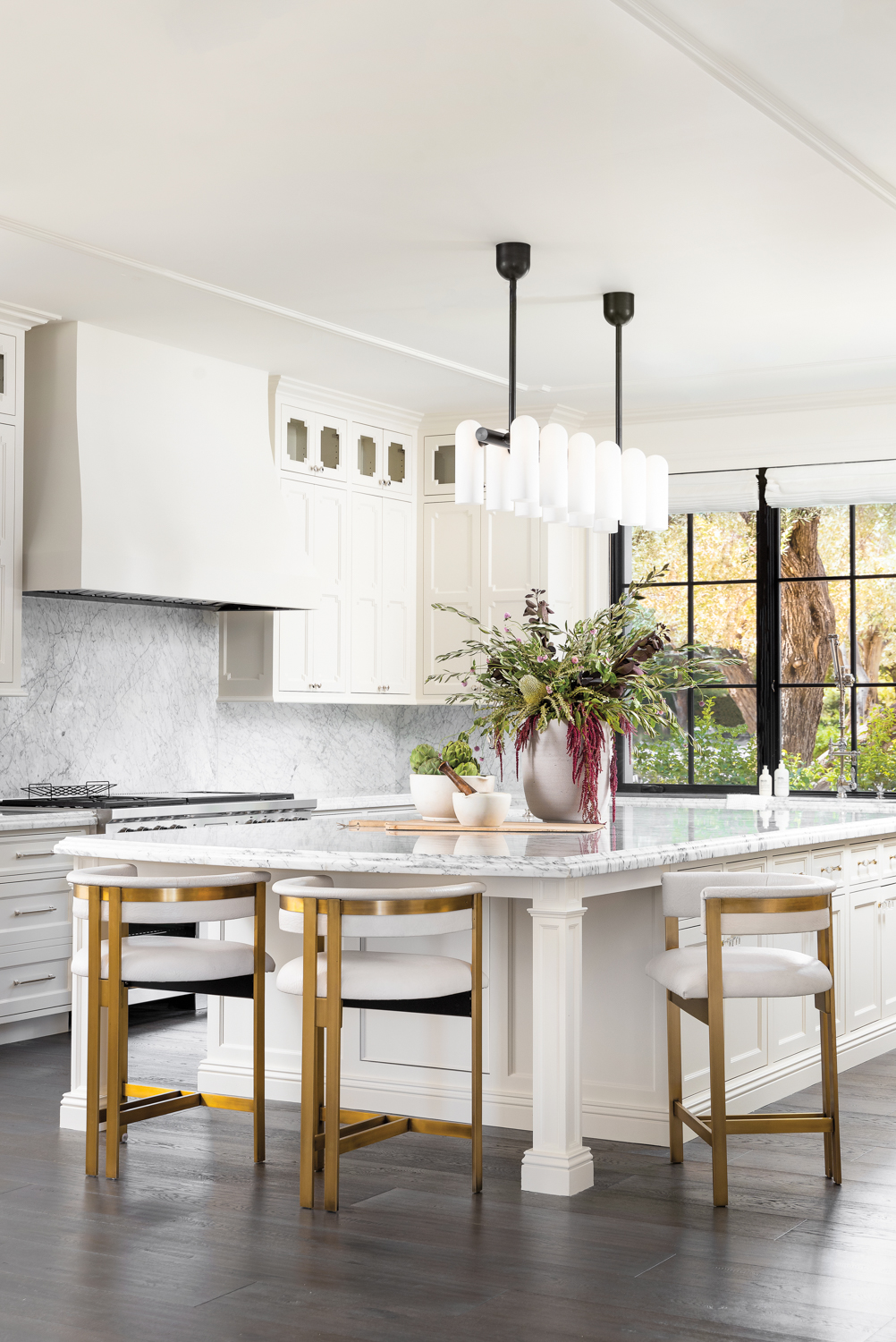 A white kitchen with brass-and-white...