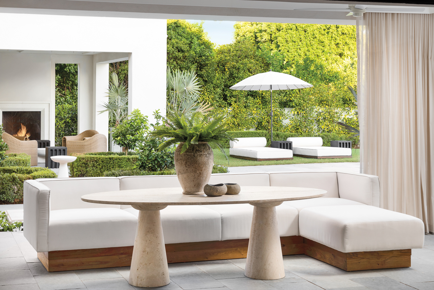 An outdoor dining table with a white sectional.