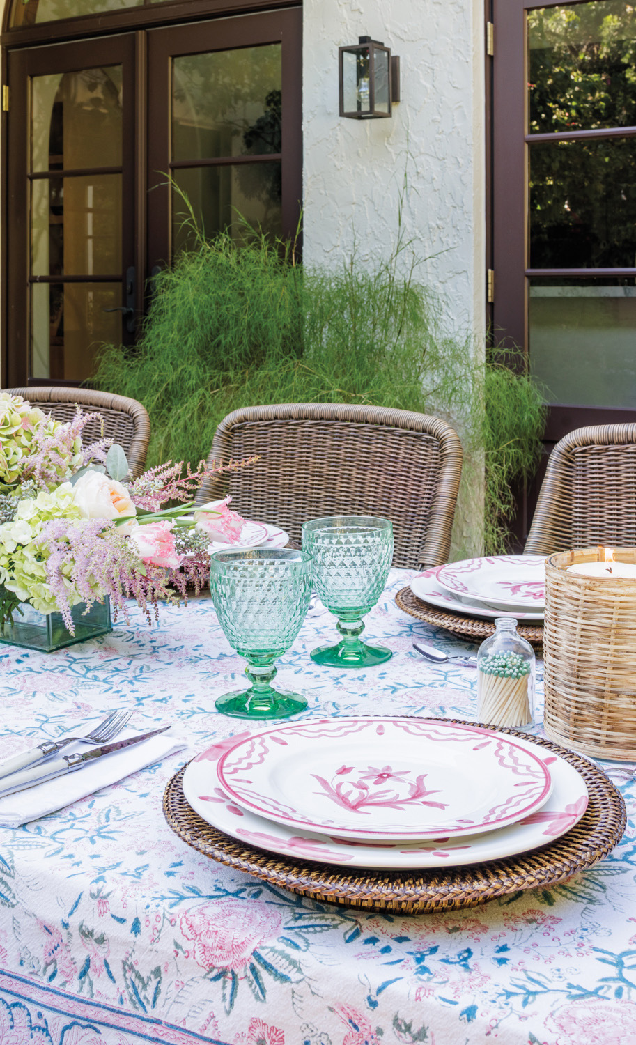 designer Constanza Collarte outdoor table setting with pink plates and green glasses