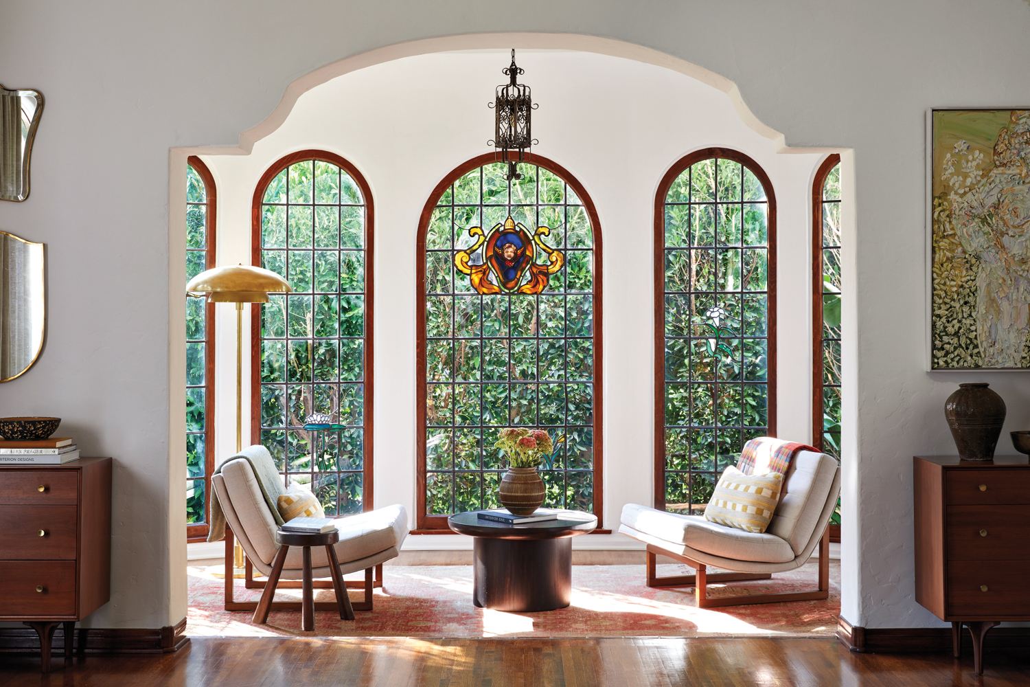 living room of Spanish-style home with stained-glass windows and two chairs and table