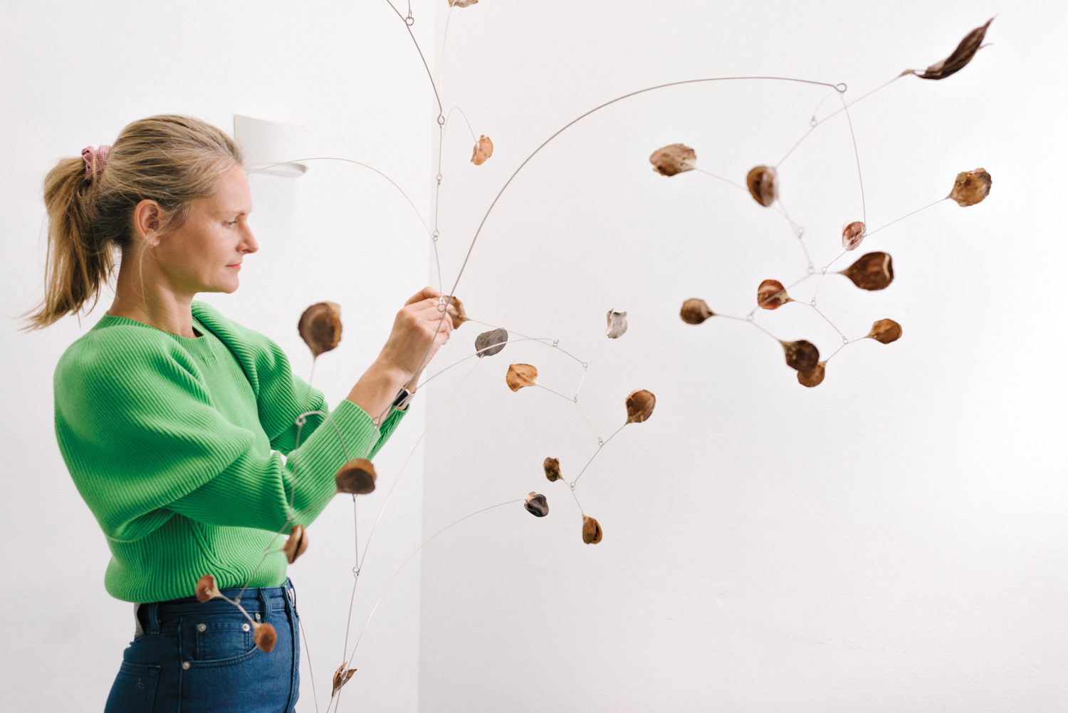 sculptor Karolina Maszkiewicz adjusts the edge of her mobile