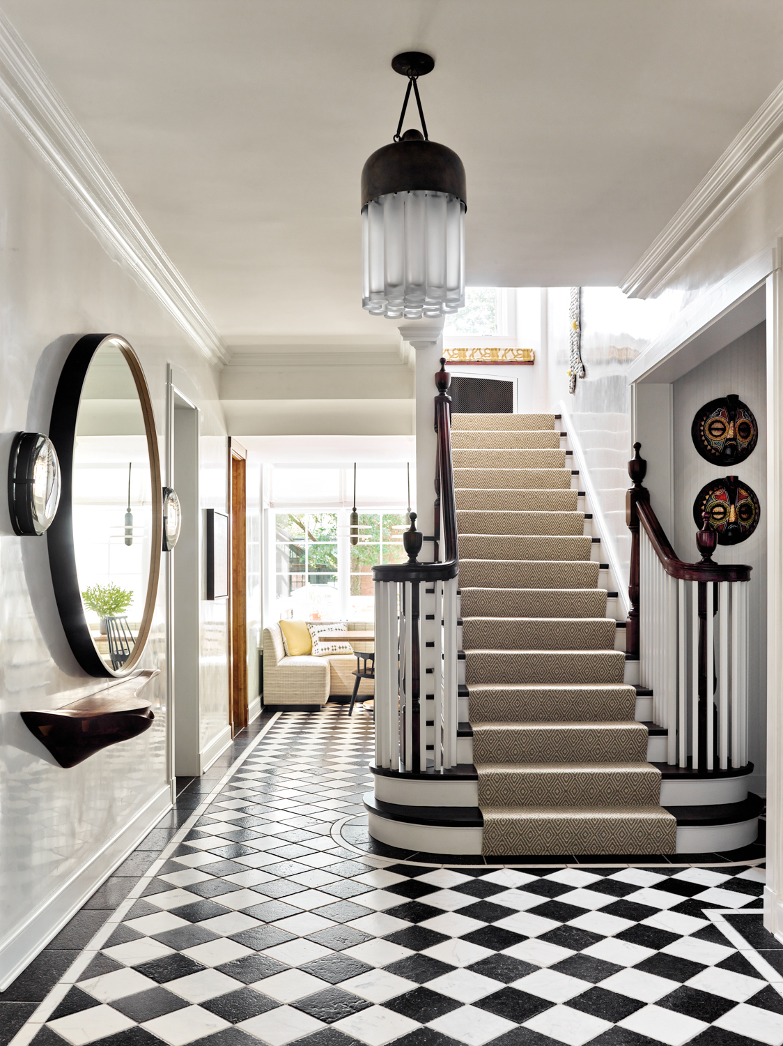 An entry with a black-and-white checkered floor and a staircase.