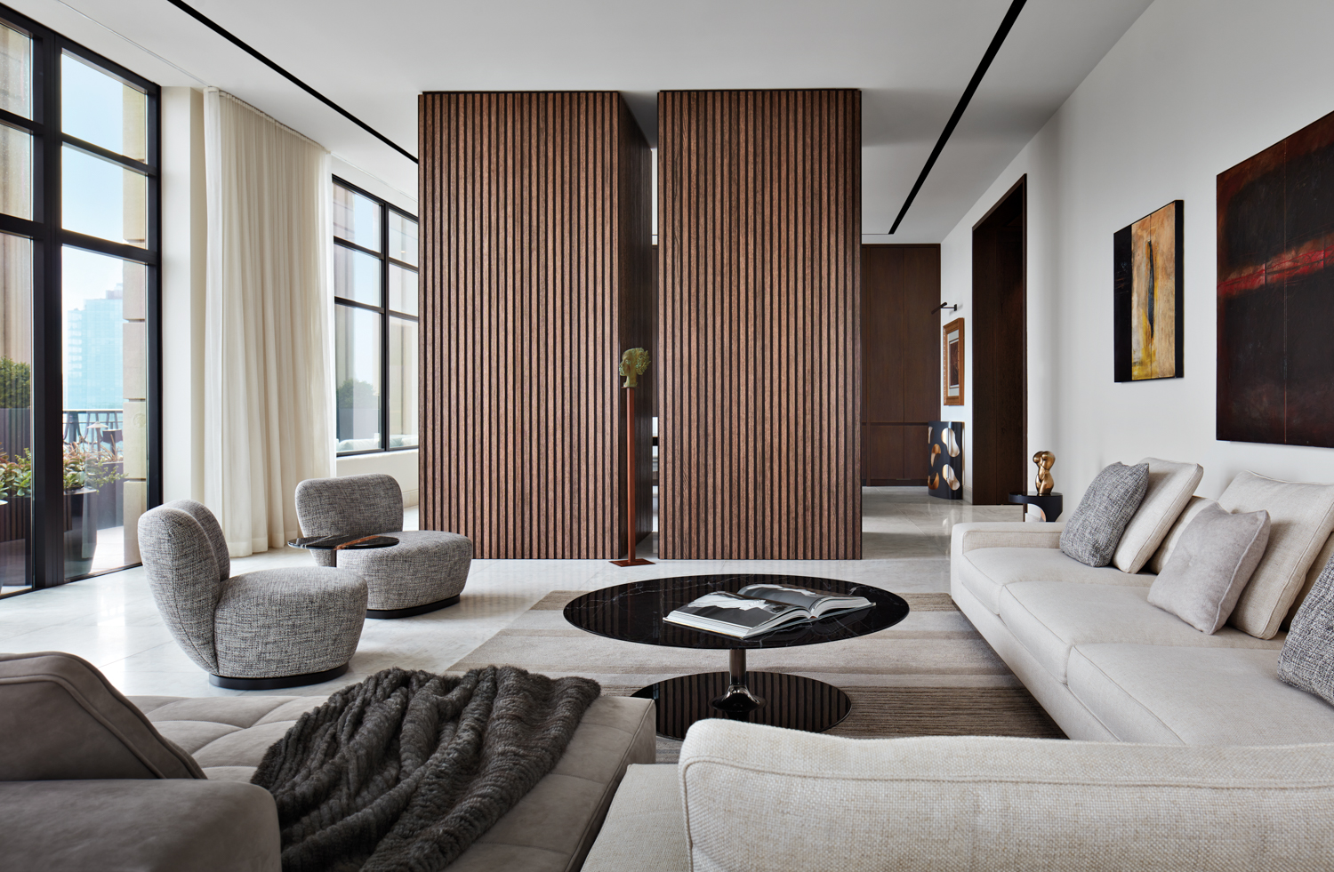 A neutral living room with two floor-to-ceiling slatted-wood forms.