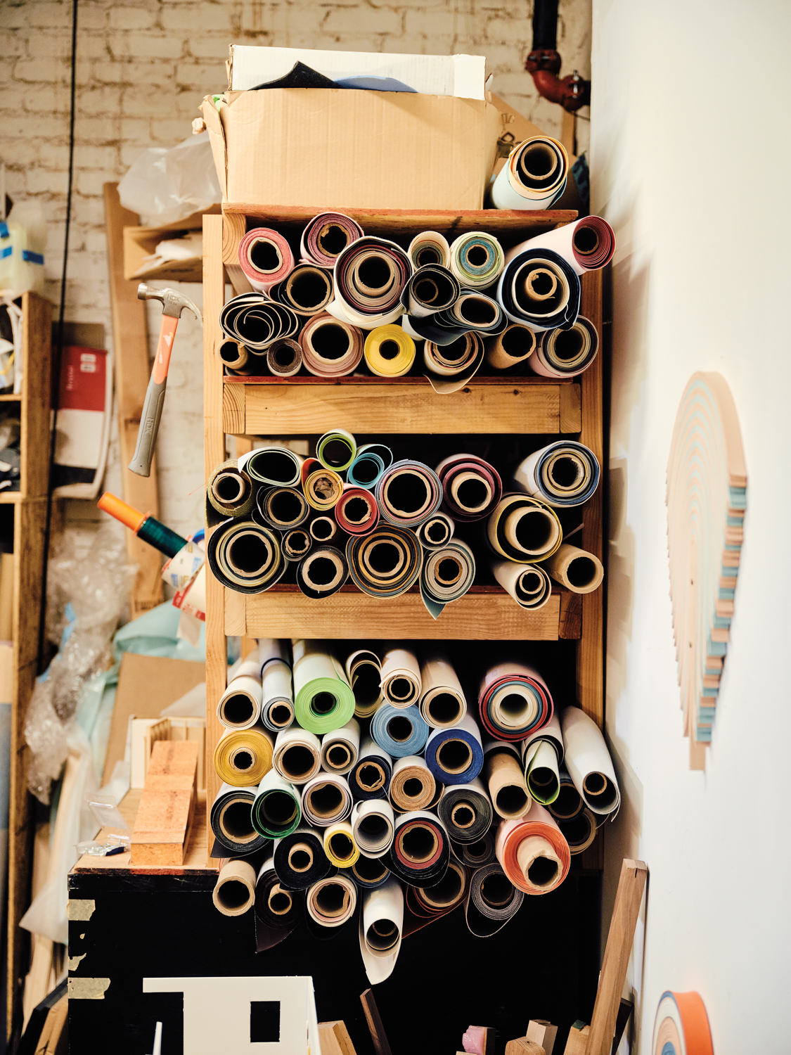 rolls of upholstery vinyl stacked in an artist studio