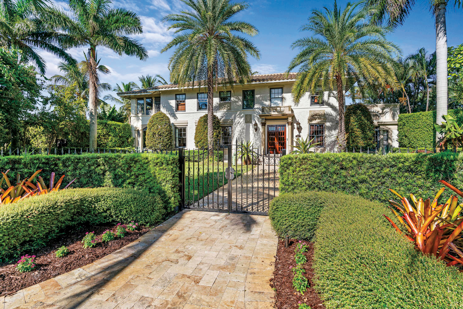 Exterior of Mediterranean Revival estate with towering palms