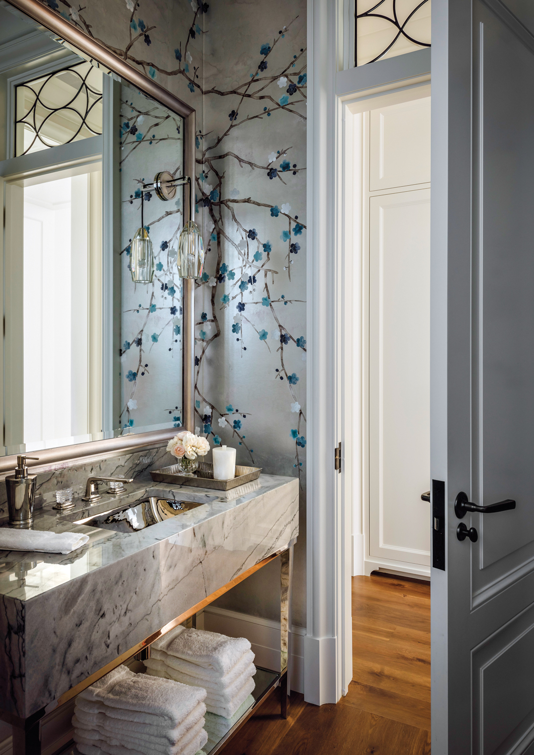 A powder room features metallic...