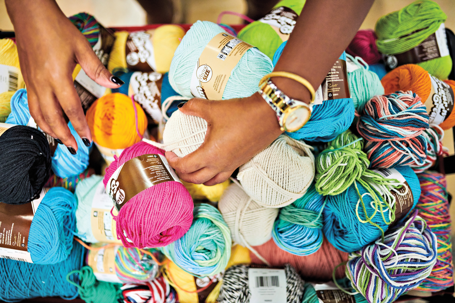 artist michelle drummond sorting through a collection of colorful yarn