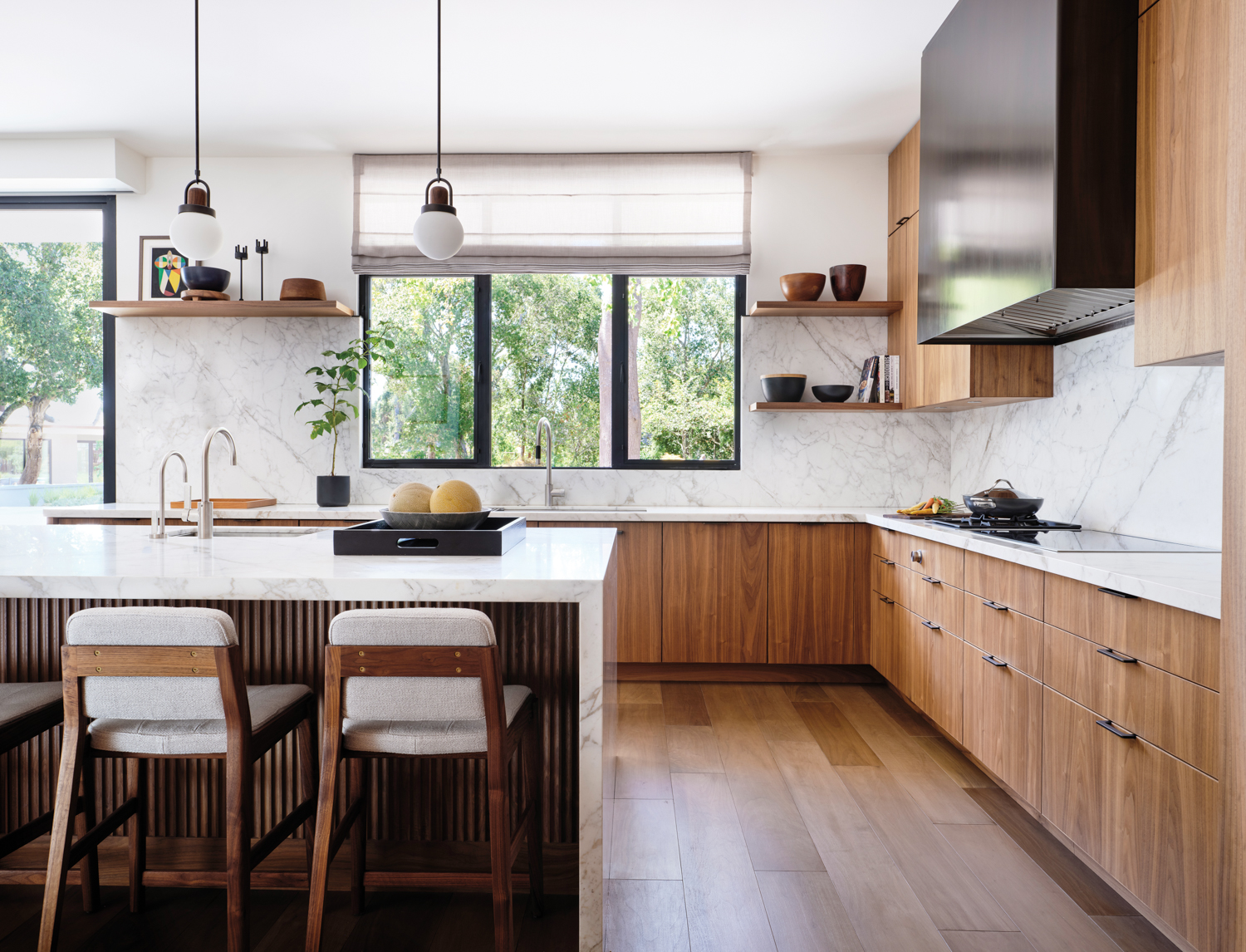 In the kitchen natural-wood cabinets are set against white walls.