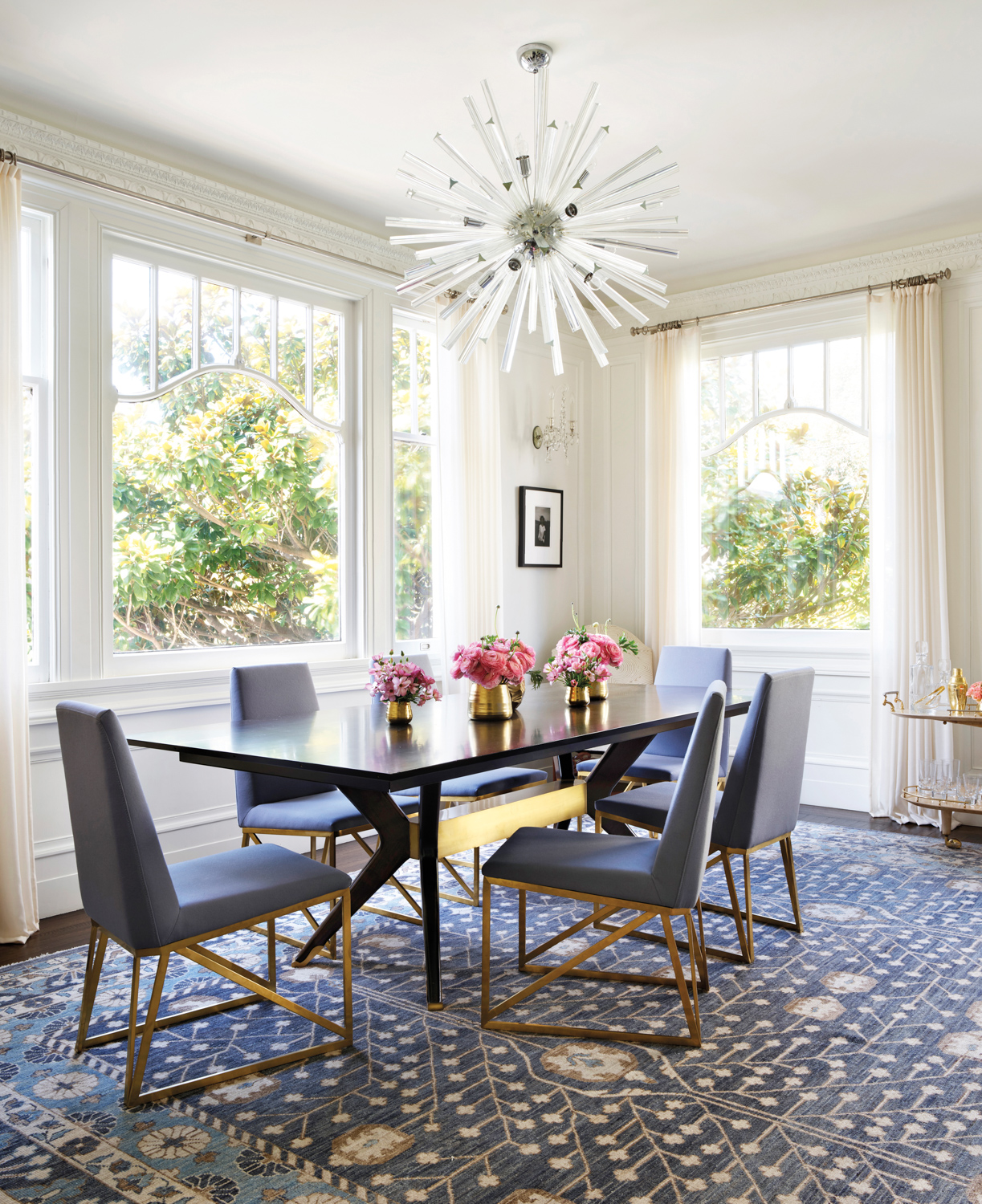 The dining room has a spiky light fixture and a modern table and chairs.