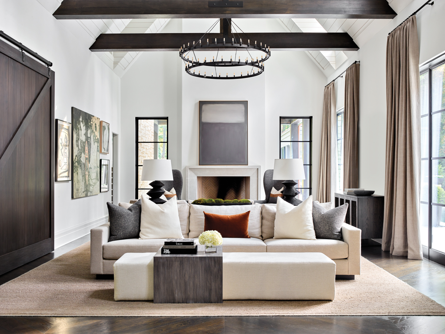 Vaulted family room with streamlined furniture, wooden ceiling beams and tiered chandelier