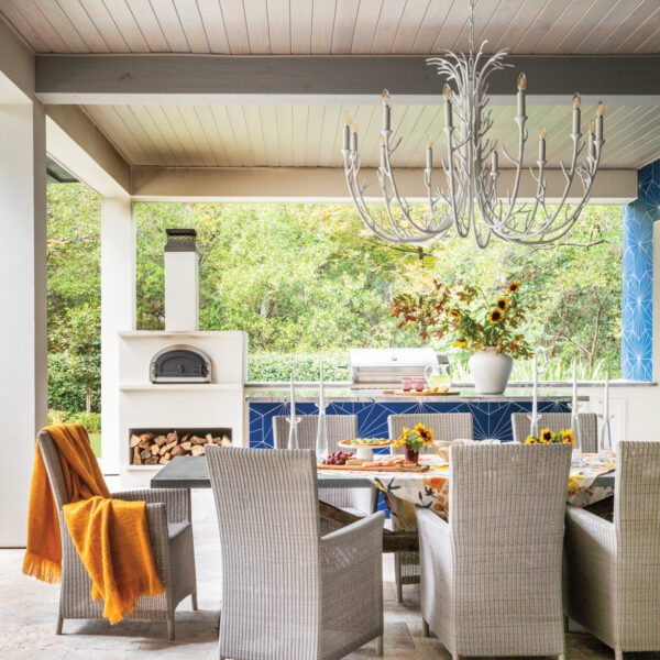 Take A Spin Around The Color Wheel In This Vibrant Houston Gem outdoor dining area with statement lighting, graphic blue tile and a pizza oven