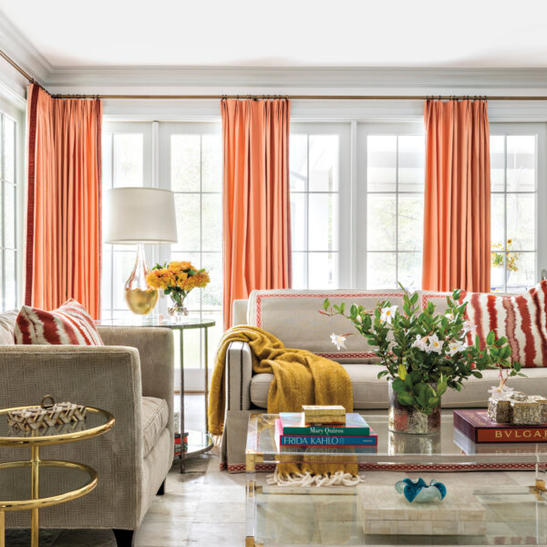 Take A Spin Around The Color Wheel In This Vibrant Houston Gem family room featuring coral accents that include draperies and accent pillows