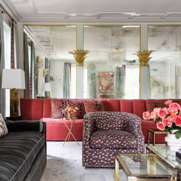 Take A Spin Around The Color Wheel In This Vibrant Houston Gem glam living room with multiple seating zones featuring a velvet upholstered banquette and mirrored walls