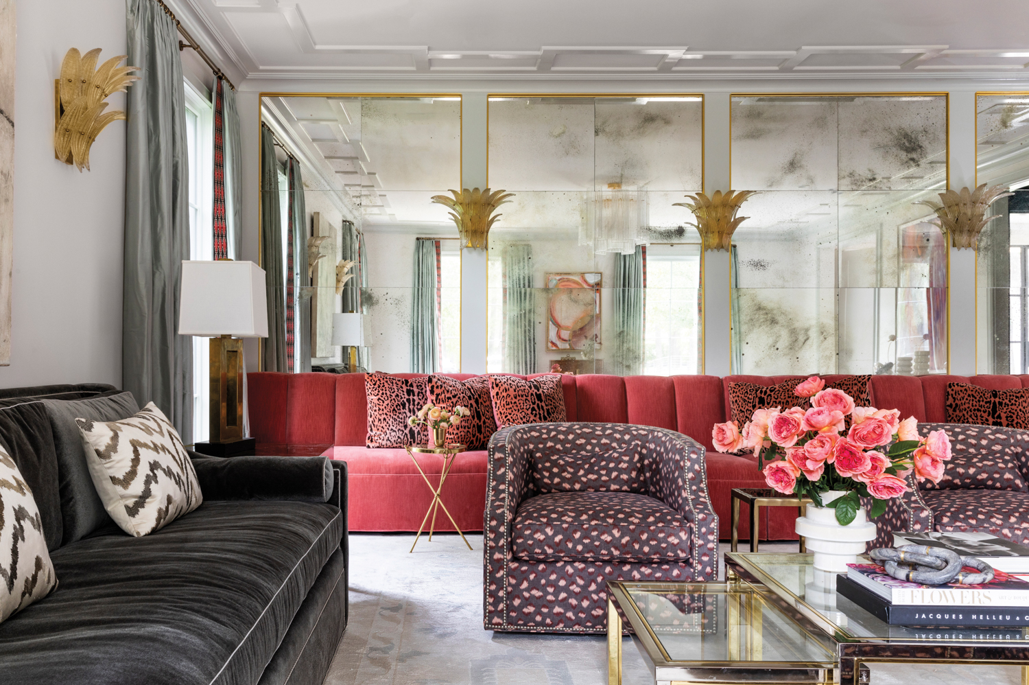 glam living room with multiple seating zones featuring a velvet upholstered banquette and mirrored walls